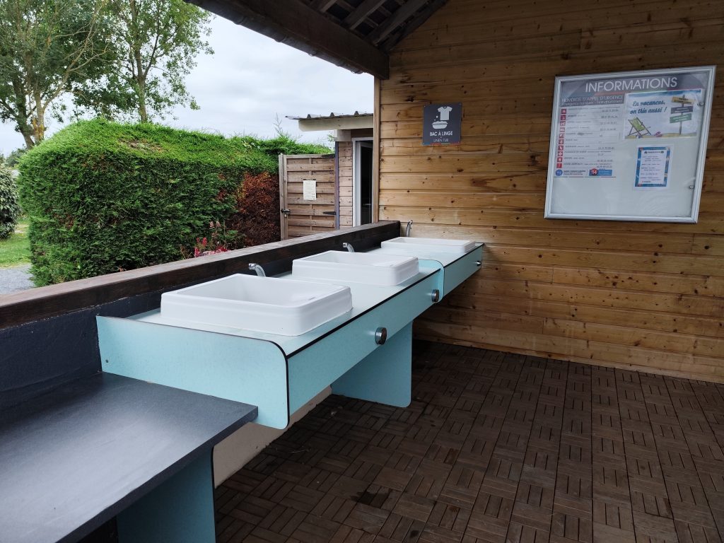 Udendørs, overdækket opvaskeområde med moderne faciliteter på Camping Le Robinson